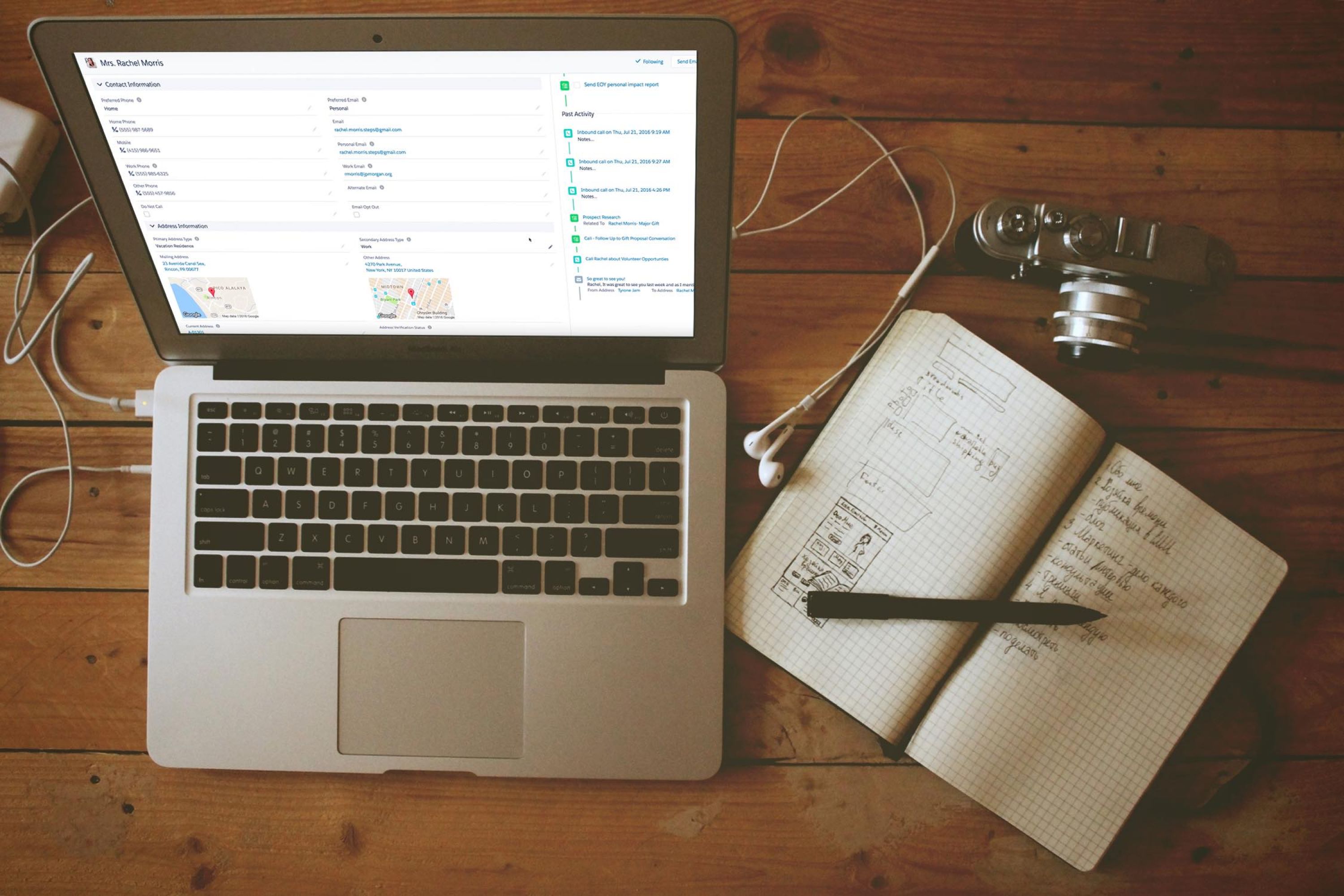 Image of open laptop on a desk with an open notebook and pen beside it.