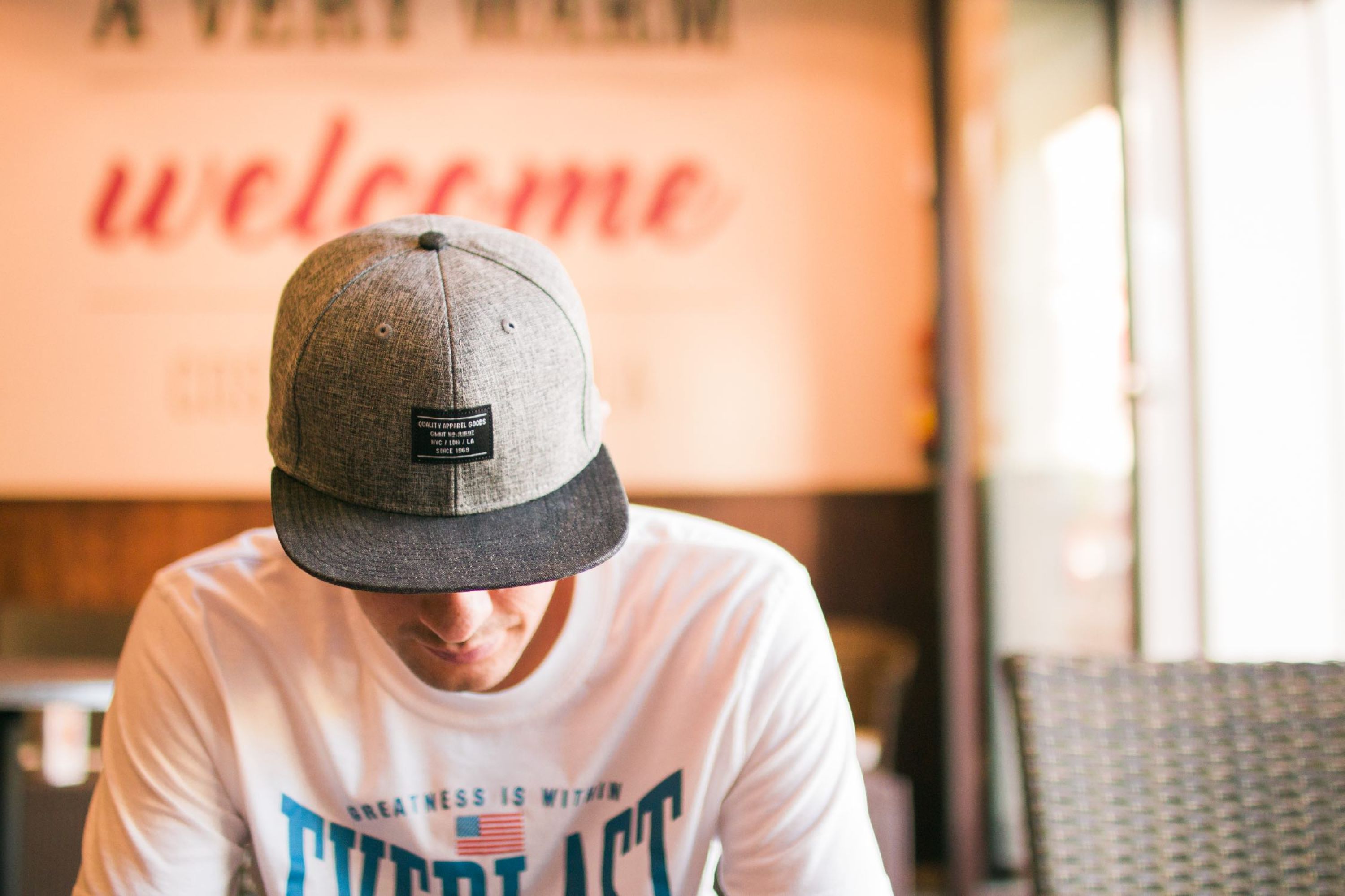 Image of man wearing a hat and looking down.