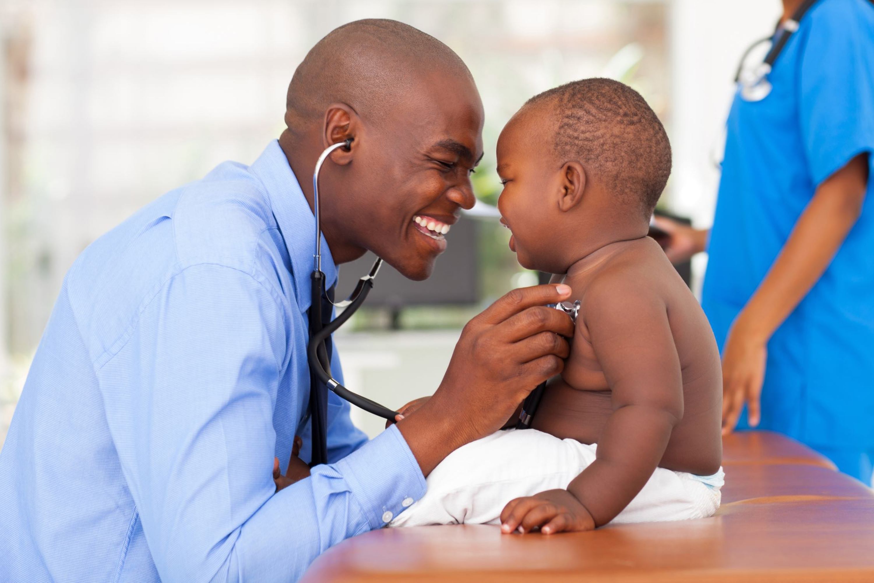 Image of man with stethoscope listening to a baby's chest.