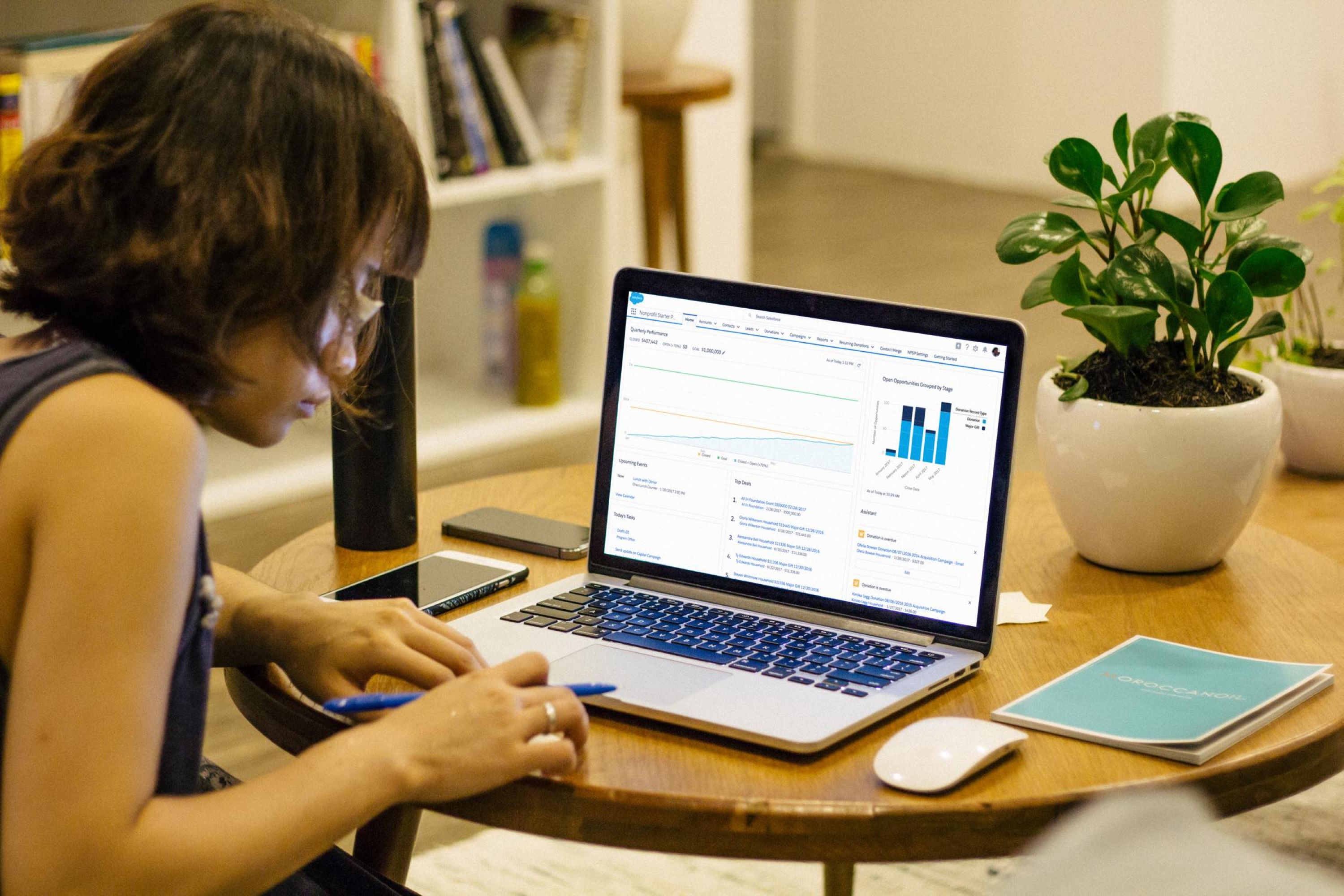 Image of woman working on a lap top computer at a table.