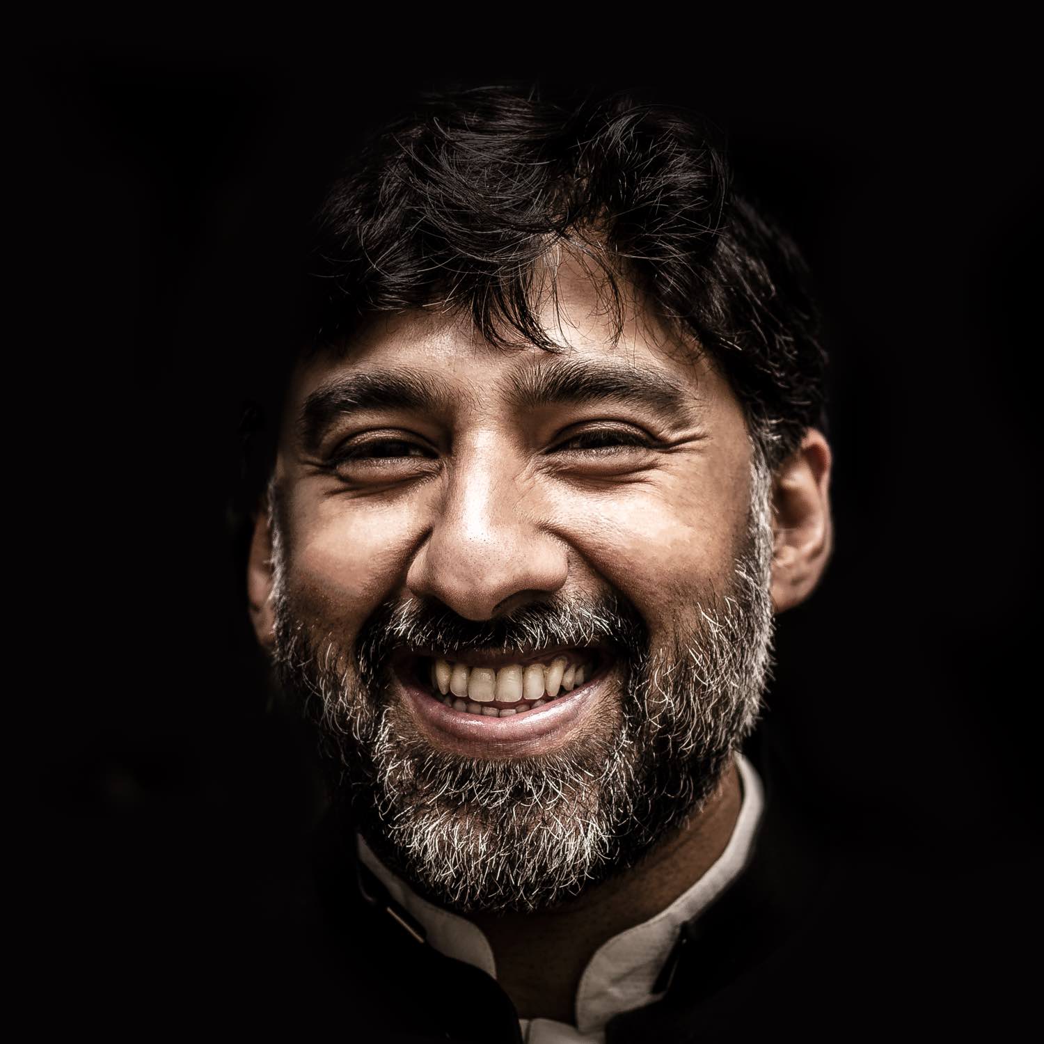 Close up image of a bearded man smiling.