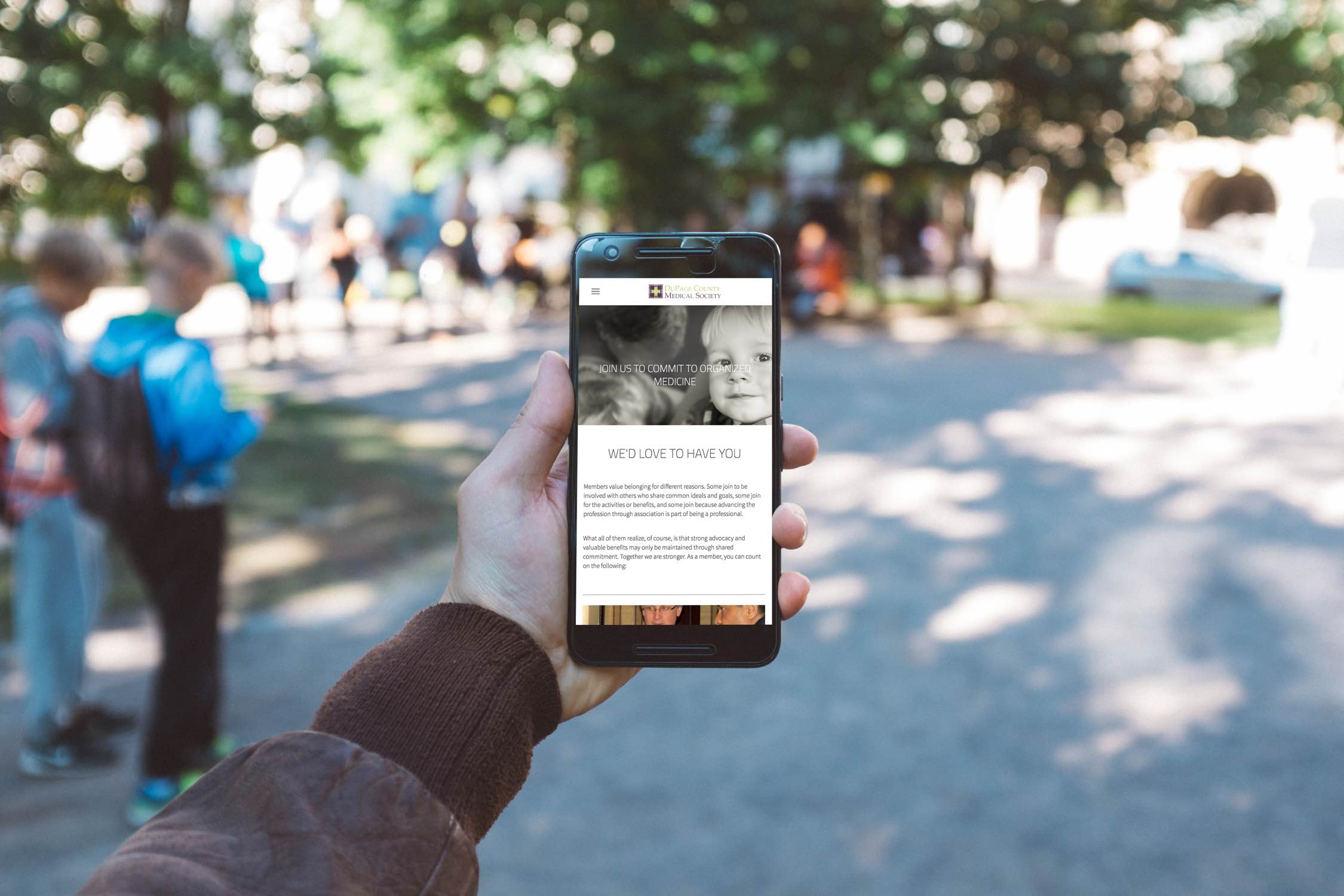 Image of hand holding a phone with image of boy and text.