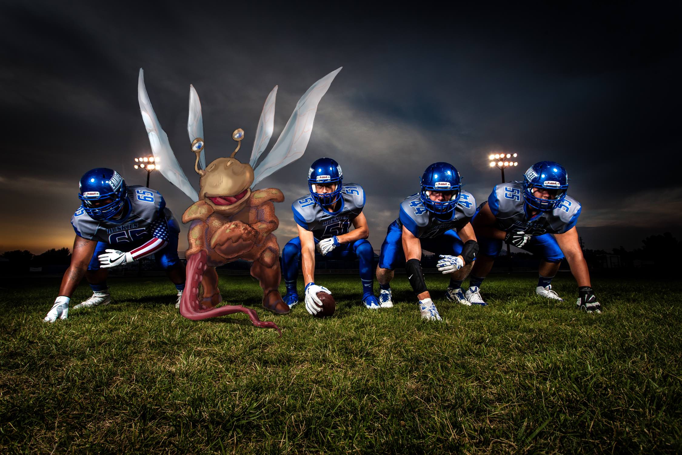 Image of football players crouching down with imaginary creature in middle.