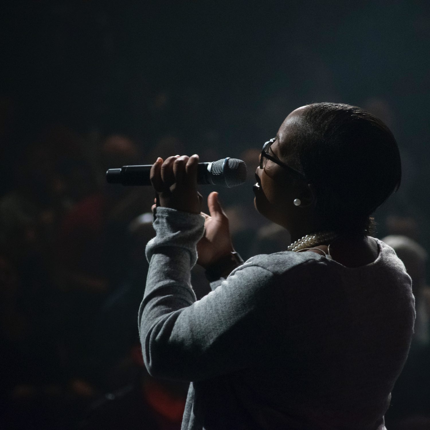 Image of a woman singing at a microphone.